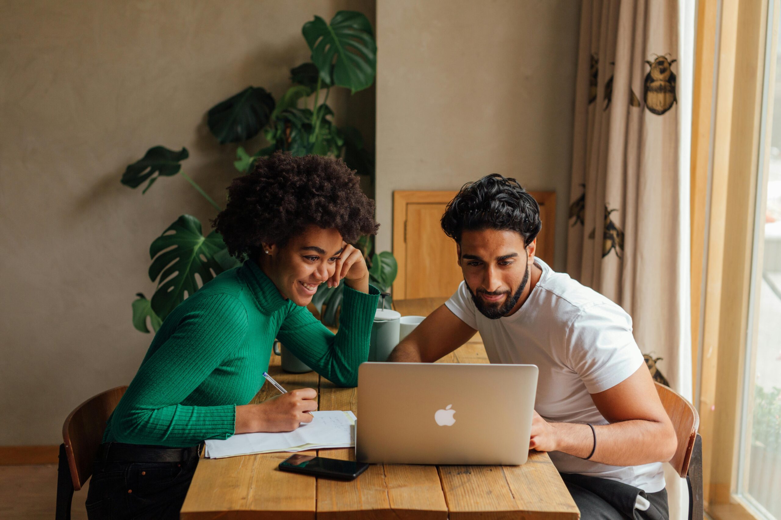 Two people of colour reading a computer
